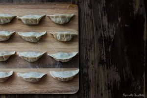 Bacon Cheeseburger Potstickers on a cutting board laid out uniformly.