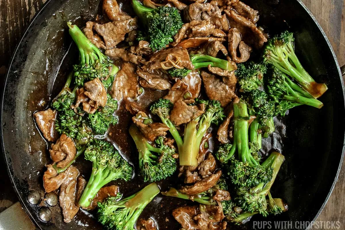 beef and broccoli finished cooking in a frying pan.
