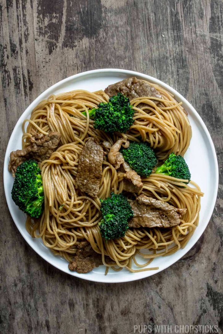 A plate of beef and broccoli noodle stir fry on a white plate