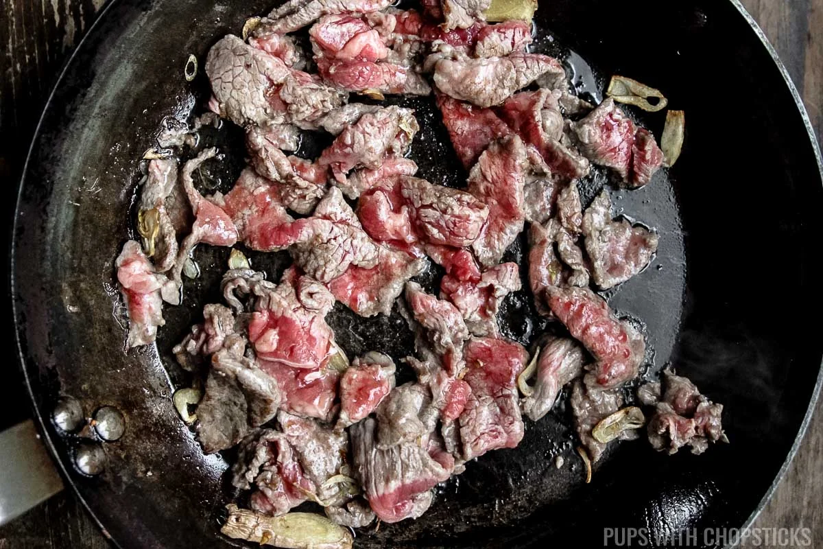 stir frying beef in frying pan.