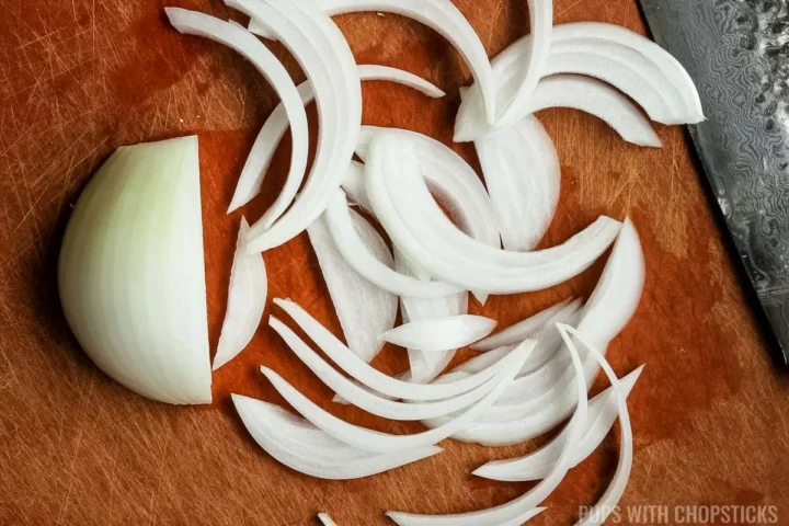 White onion sliced on a cutting board.