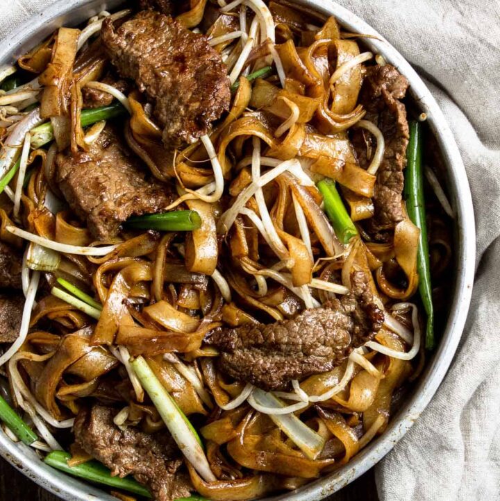 A close up for Chinese beef chow fun noodles in a metal bowl