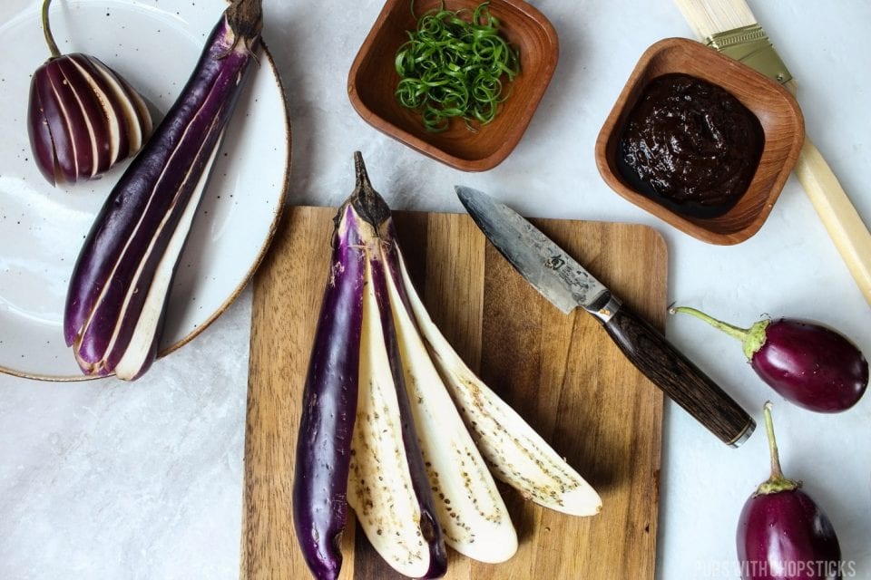 Eggplant that has been cut lengthwise and fanned out on a cutting board