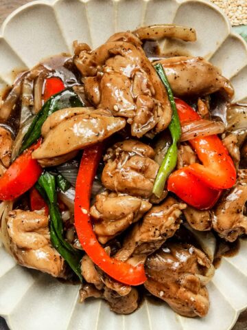 chinese black pepper chicken on a beige plate.