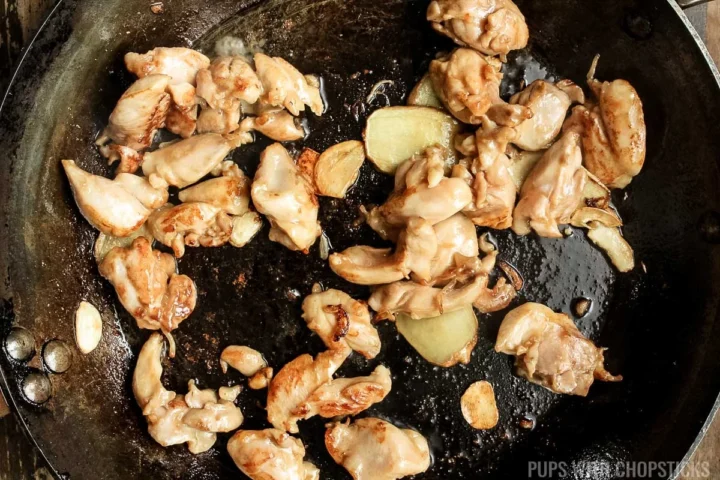 stir frying chicken in the frying pan.