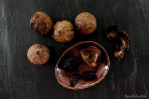Black Garlic peeled and whole bulbs being shown on the table