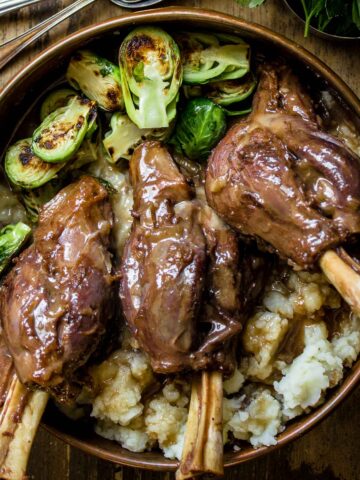 Closeup of Braised lamb shanks with red wine, and miso served with brussel sprouts and mashed potatoes
