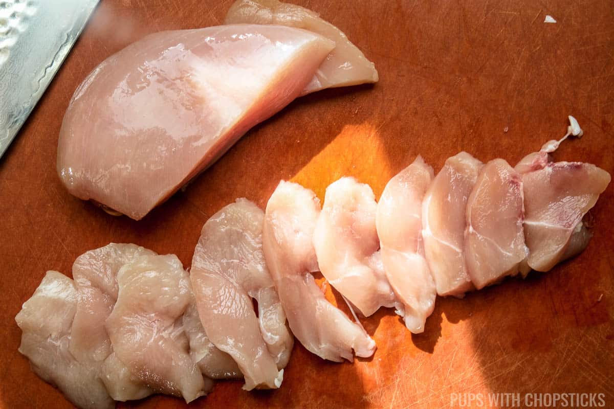 Thinly sliced chicken breast on a cutting board