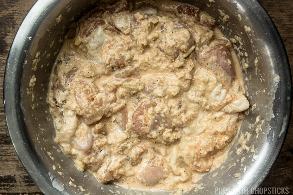 Chicken being marinated in ginger, garlic, onion and mixed with corn starch.