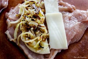 Filling the chicken breast with caramelized onions and cheese