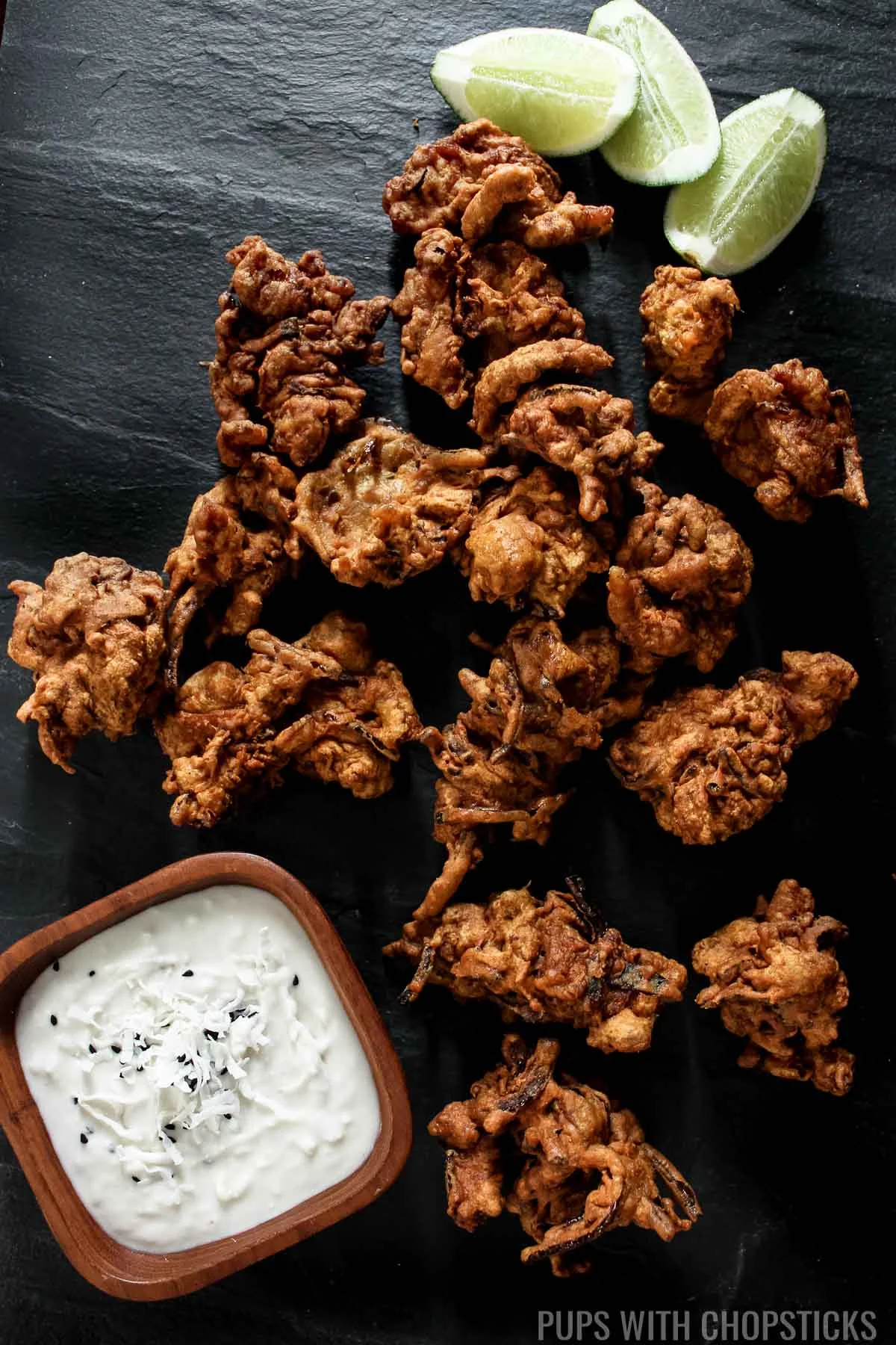 Crispy chicken pakoras served with a side of lime.