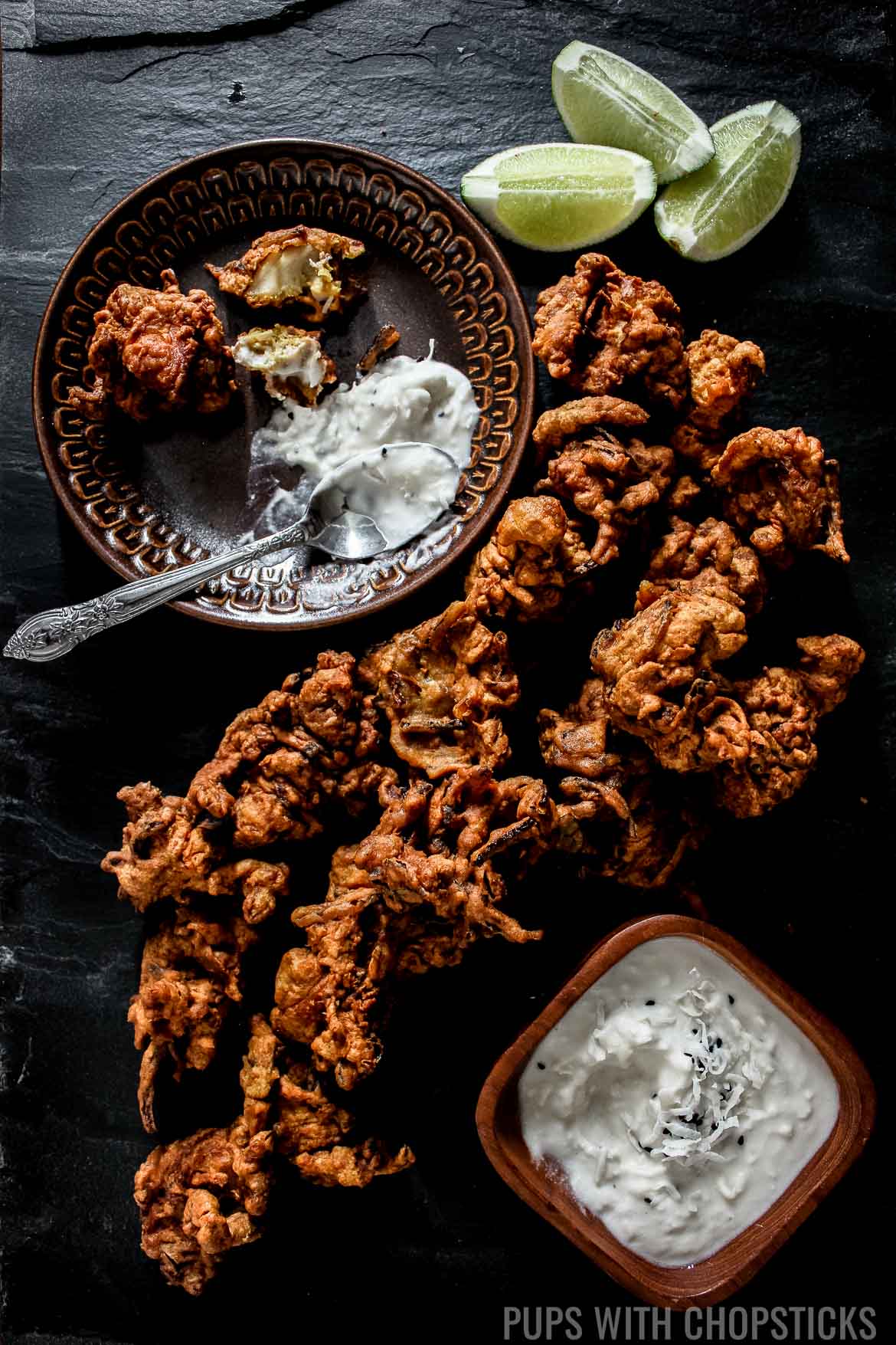 Chicken Pakora with Creamy Coconut Dip laid out on a table with limes