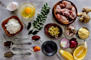 Ingredients for Chicken Pakora (boneless chicken, onions, potato starch, lemon, garlic, ginger, fish sauce, curry leaves, eggs, chickpeas flour, spices)