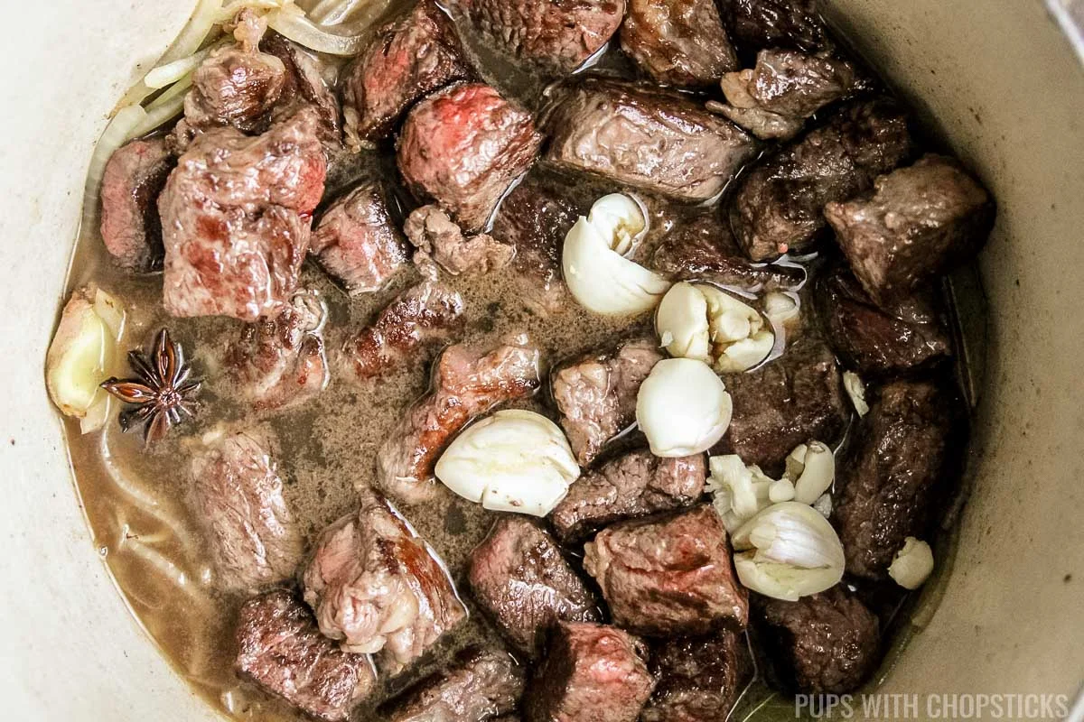 beef being simmered in a pot.