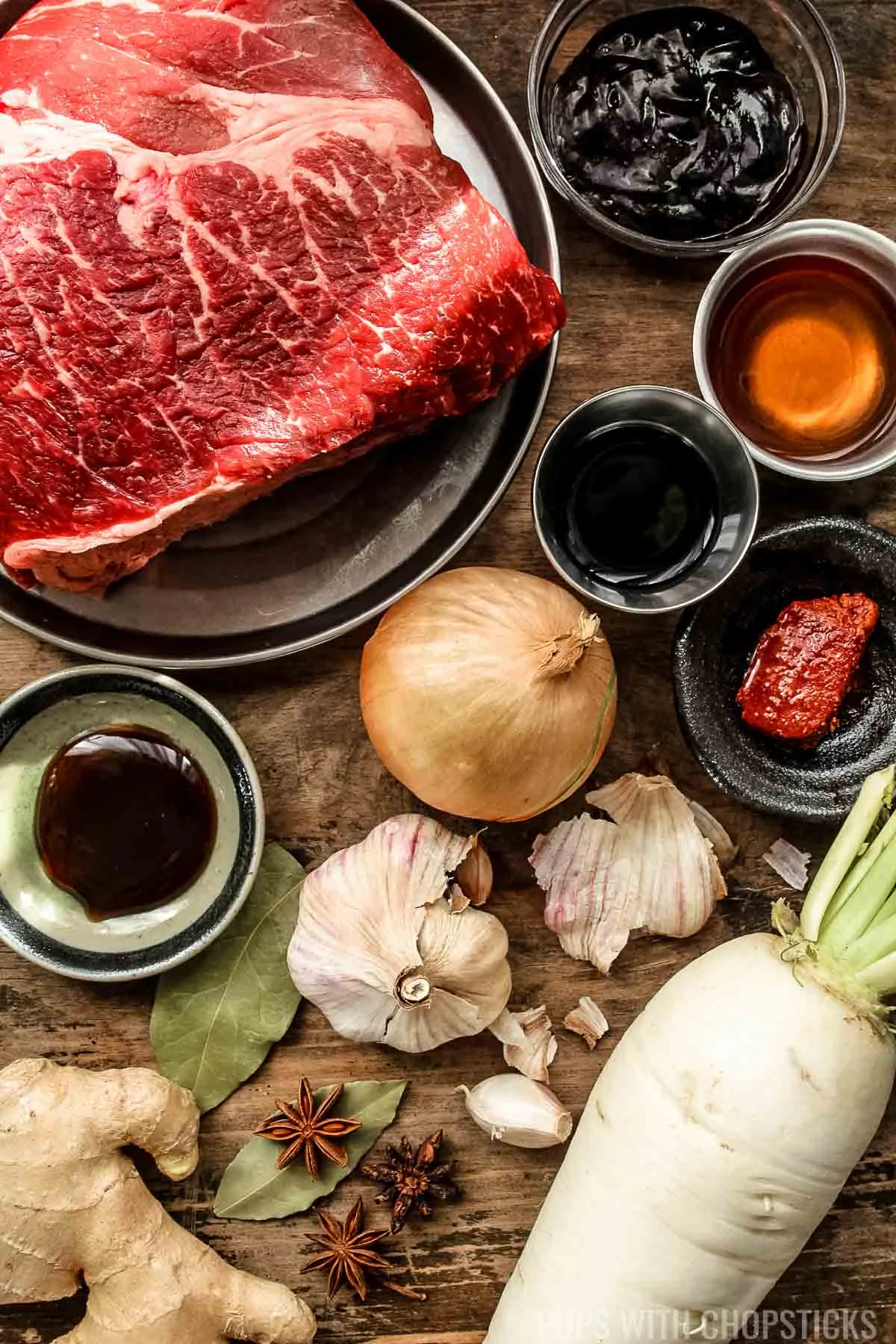 Ingredients for Chinese beef stew (beef steak, hoisin, oyster sauce, cooking wine, soy sauce, garlic, onion, star anise, bay leaves, daikon, ginger)