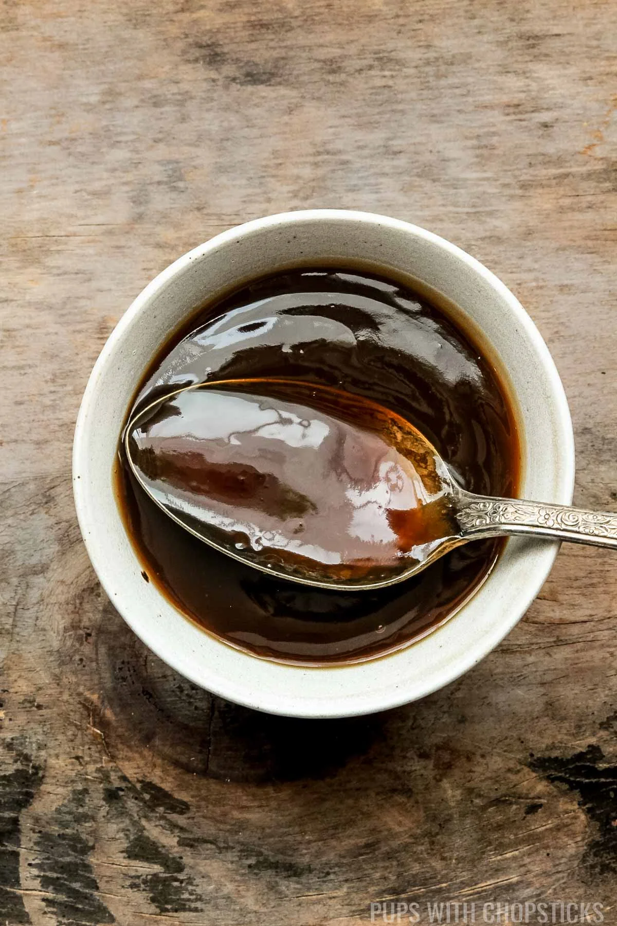 Chinese brown sauce in a white bowl with a spoon.