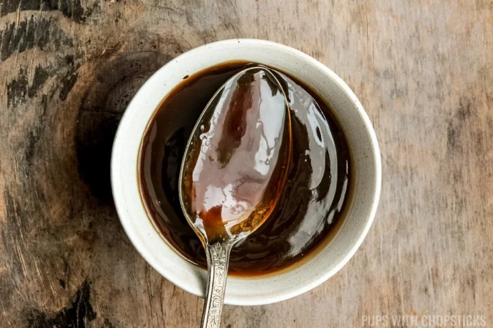 Chinese brown sauce in a white bowl with a spoon.