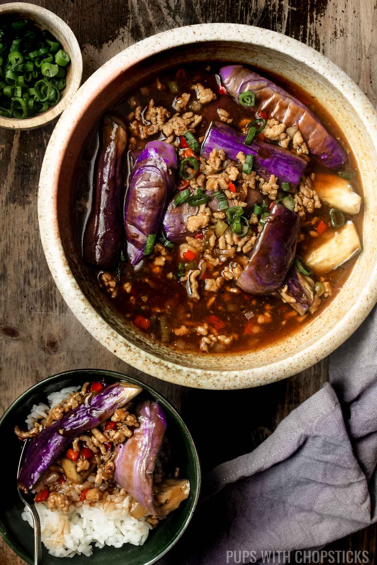 OverheadChinese eggplant with garlic sauce in a large bowl with a bowl of rice on the side