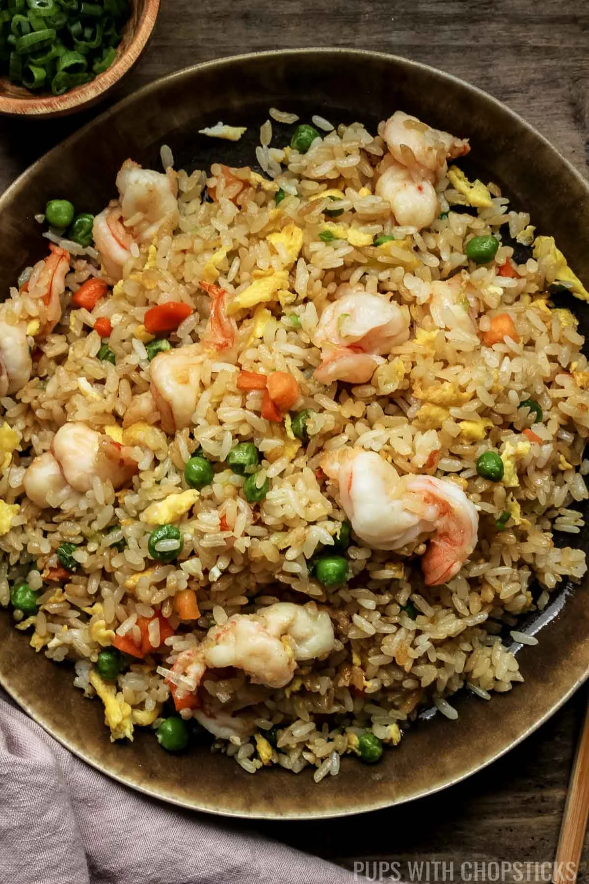 chinese shrimp fried rice on a brown plate.
