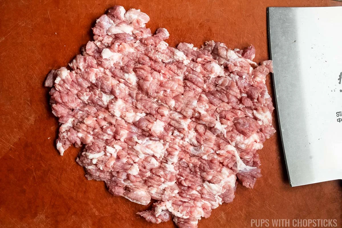 chopping minced pork by hand.