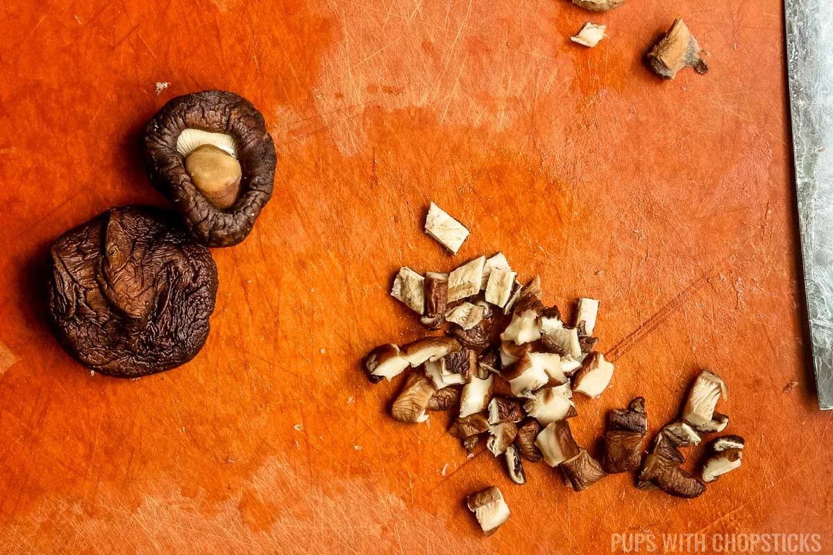 dicing shiitake mushrooms on cutting board.