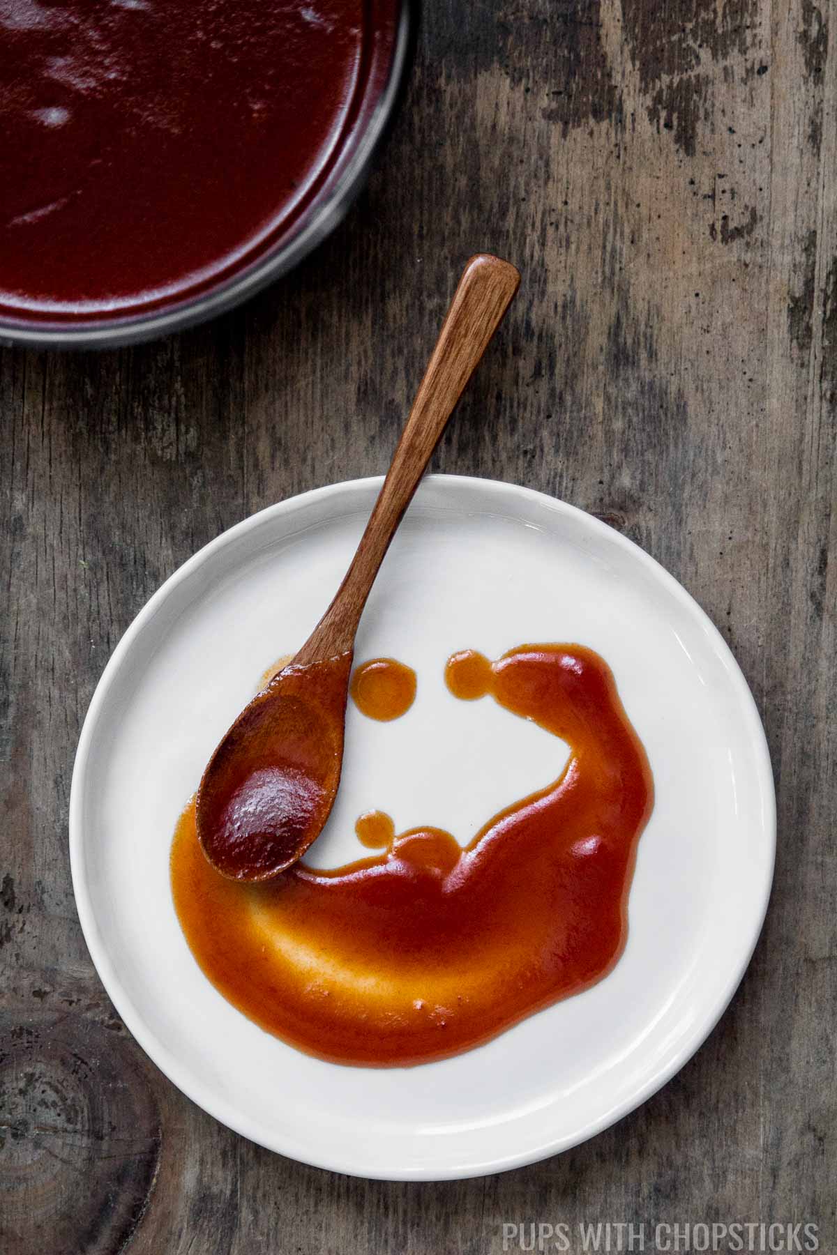 A small white plate with Chinese sweet and sour sauce on it.