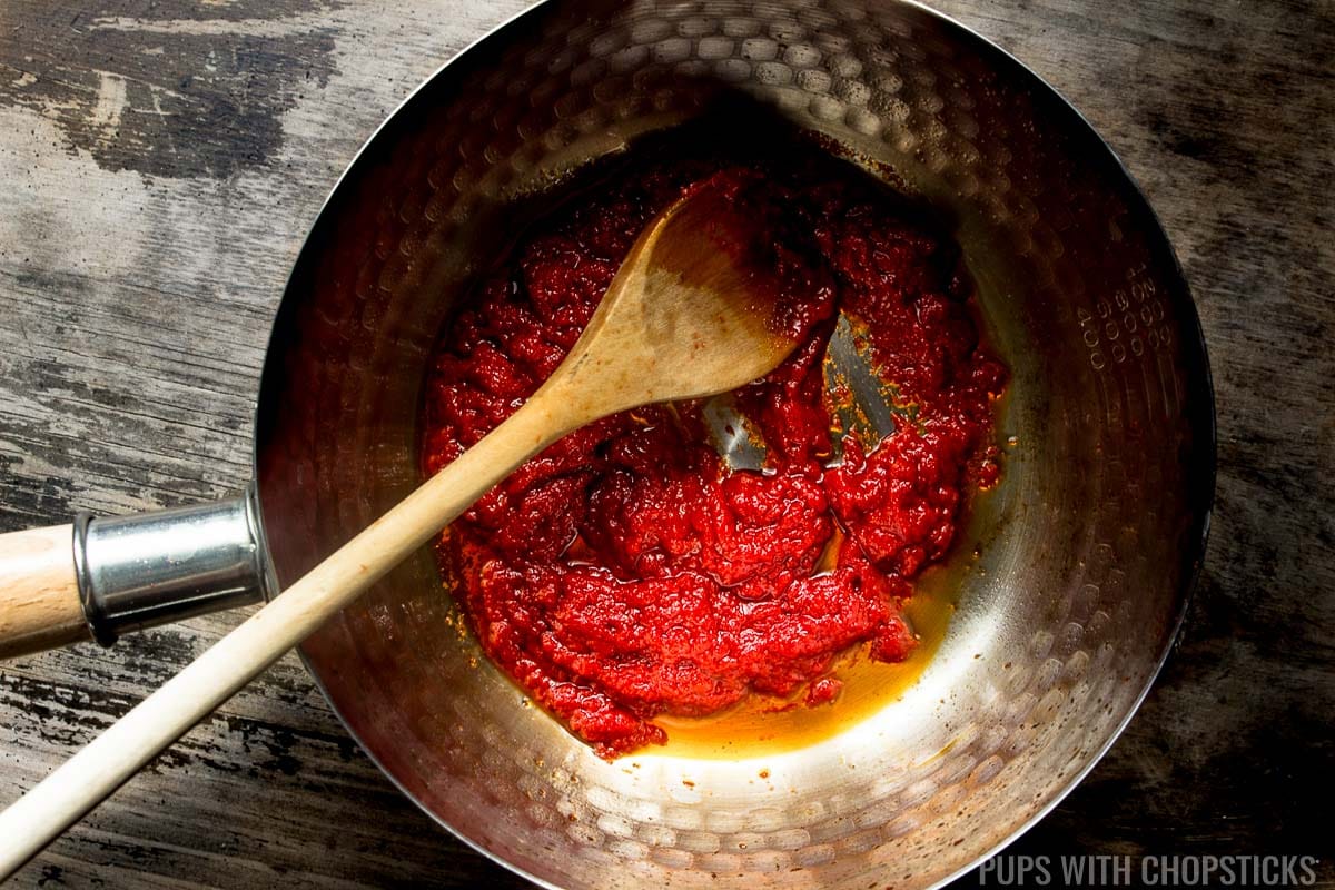 Tomato paste being toasted in oil to bring out the flavor of sweet and sour sauce