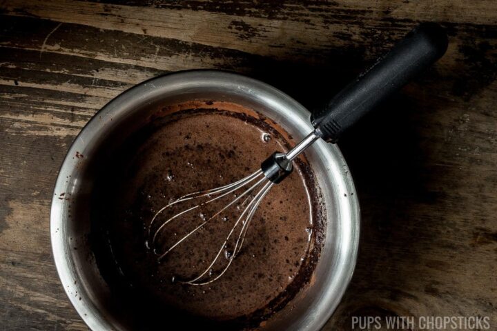 black sesame chocolate custard filling in a bowl with a whisk.