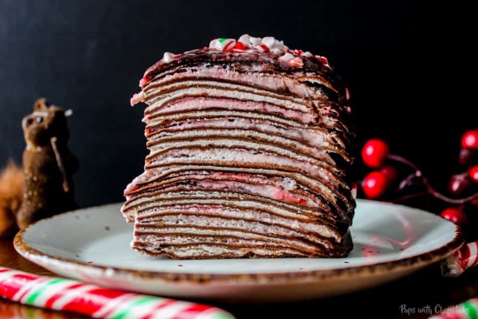 A slice of Candy Cane Chocolate Crepe Cake on a plate on a table