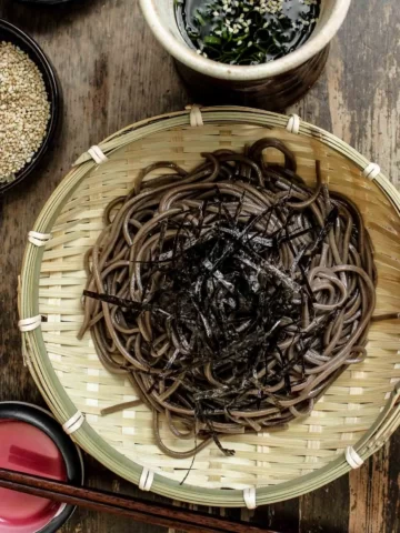 Cold zaru soba noodles being served in a bamboo bowl