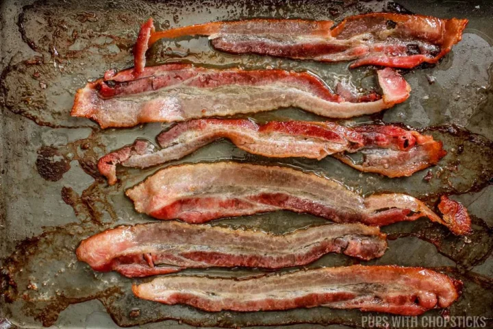 bacon being baked on a cookie tray.