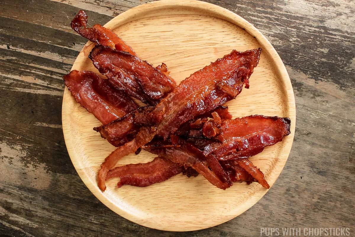 candied bacon on a wooden plate.