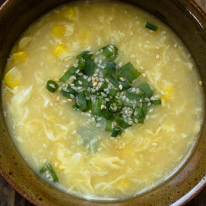 Closeup of egg drop soup in a brown bowl