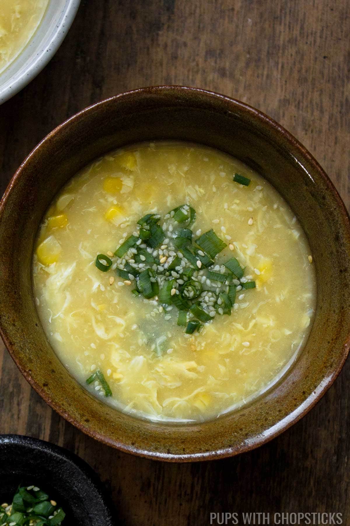 Egg drop soup in a bowl with a side of vermicelli noodles and green onions