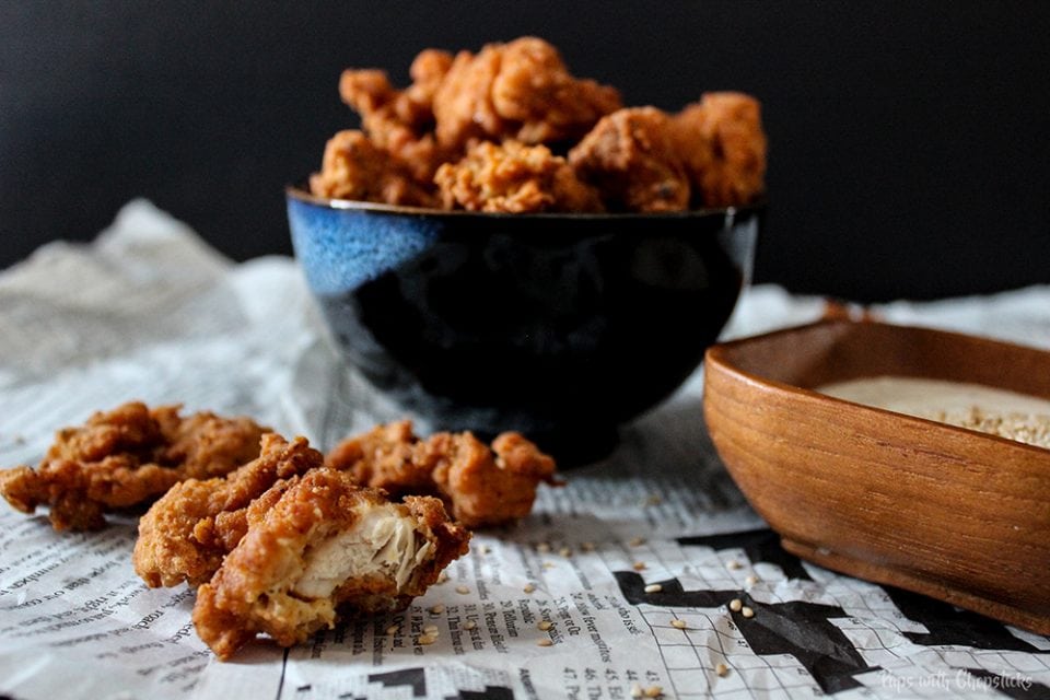 Crispy Buttermilk Popcorn Chicken in a bowl and on newspaper on a table