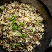 Cumin Beef Fried Rice in a black bowl on wooden table