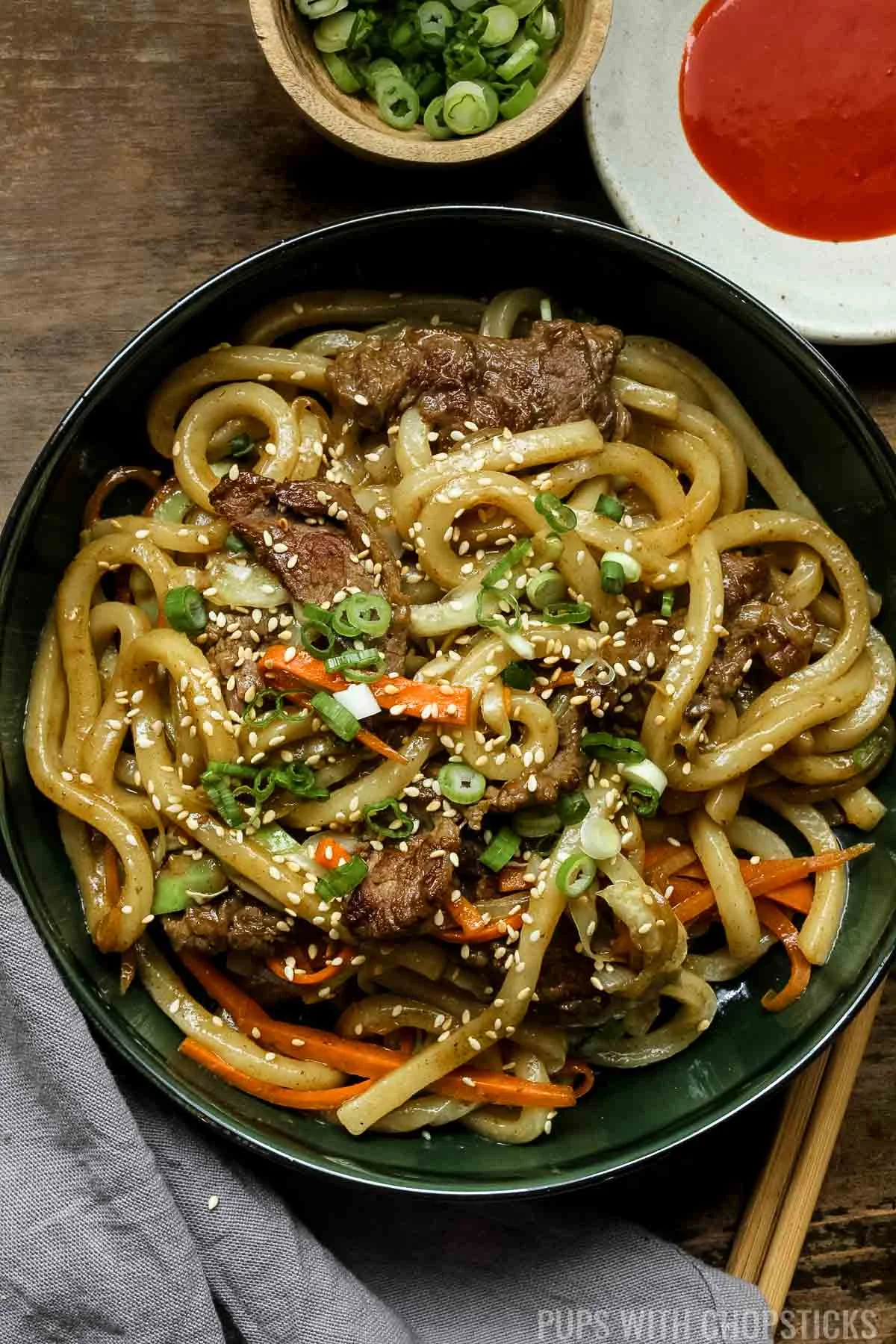 curry beef yaki udon on a green plate and wooden chopsticks.