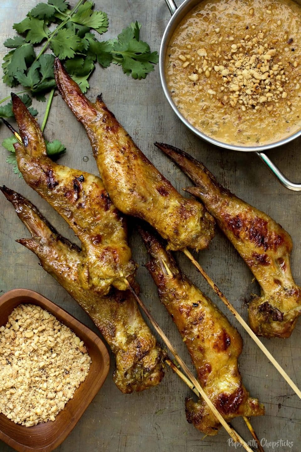 A display of Chicken Satay Wings with a bowl of crushed peanuts and satay peanut sauce