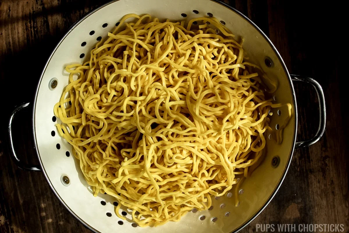 Drained Hakka noodles in a colander.