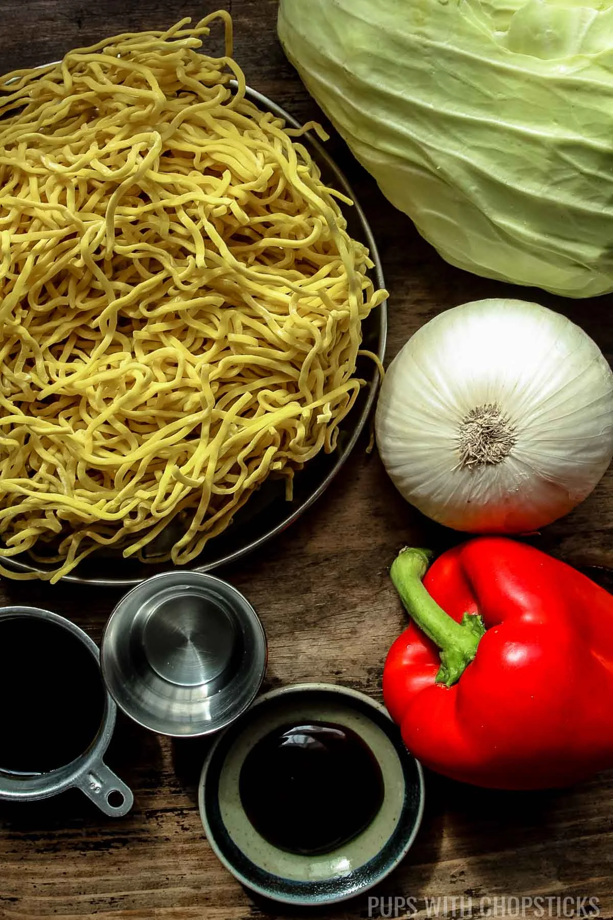 Hakka noodles ingredients (hakka noodles, cabbage, red bell pepper, white onion, garlic, soy sauce, oyster sauce, vinegar)