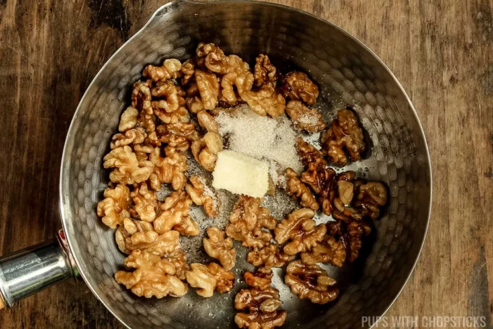 adding butter and sugar to toasted walnuts.