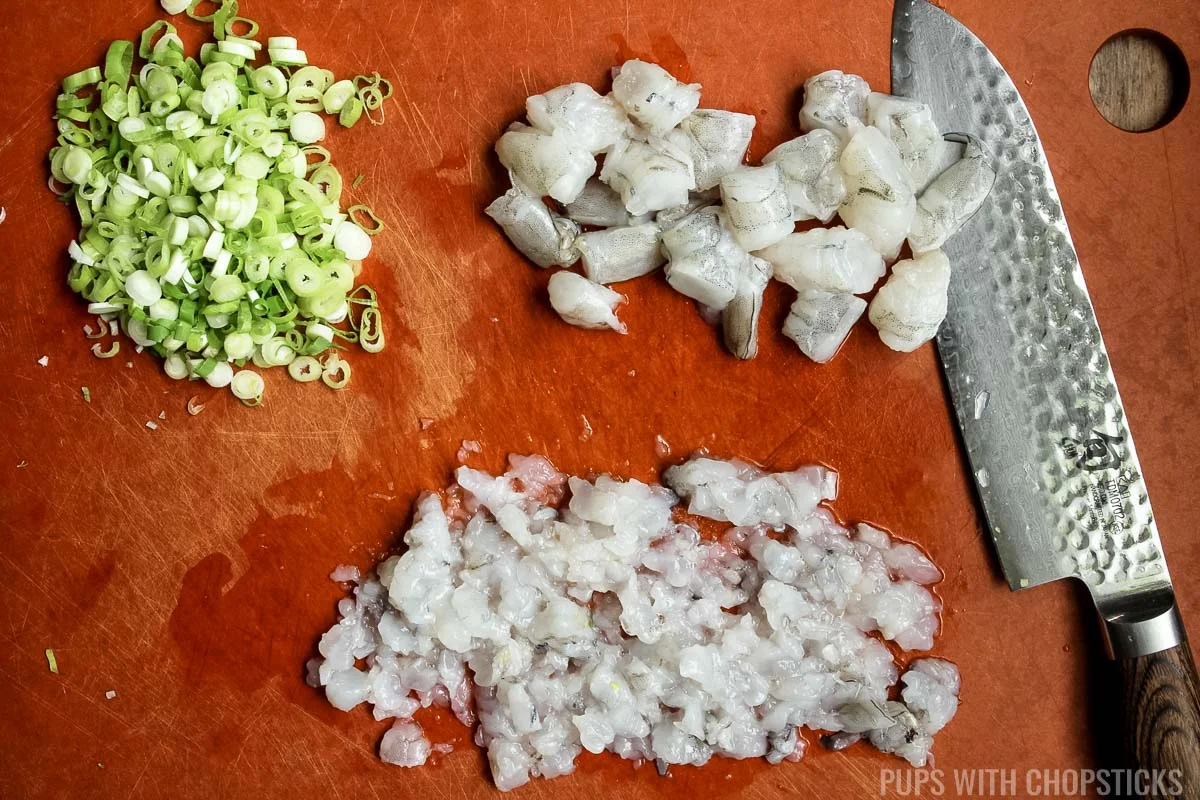 Finely chopped shrimp and finely minced shrimp on a cutting board