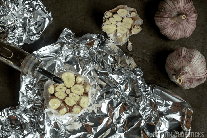 Garlic wrapped in foil on a table.