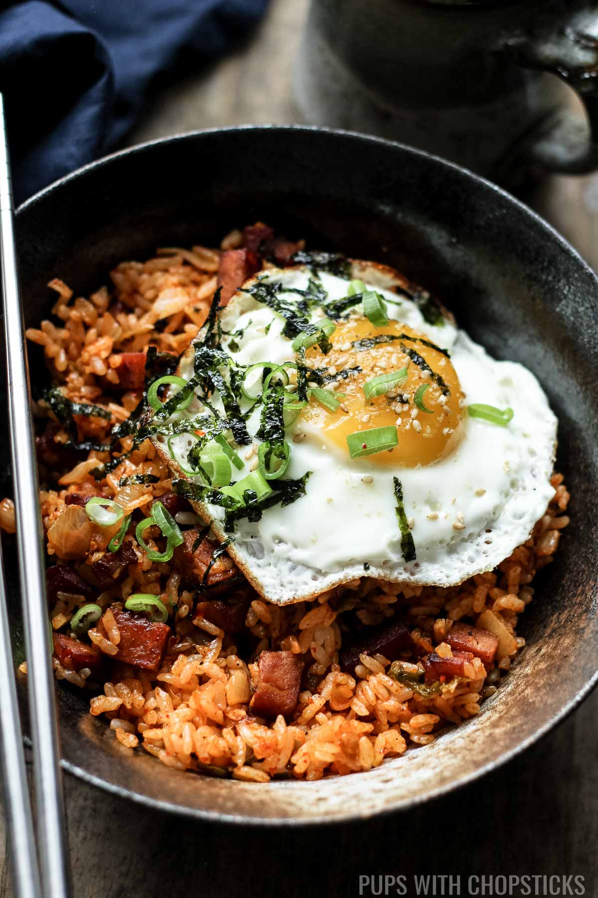 A large bowl of kimchi fried rice with spam and a fried egg on top