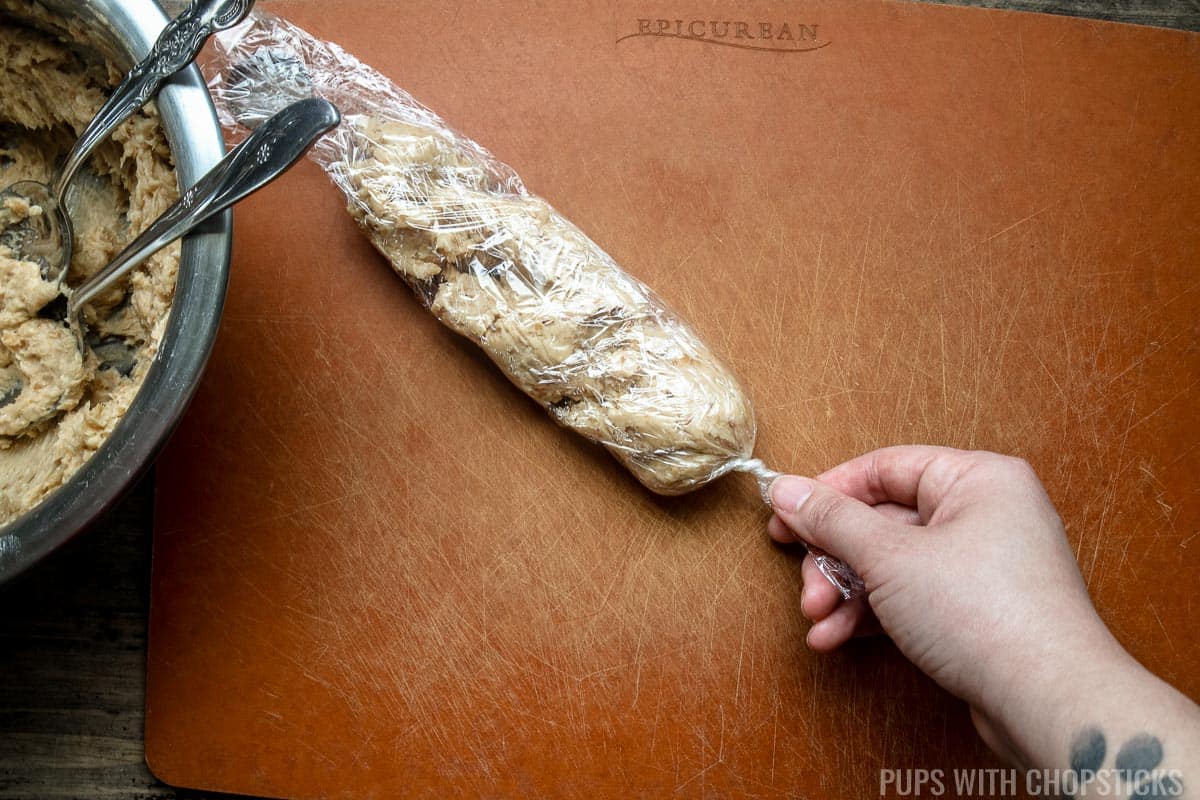 one end of plastic wrap being twisted to secure miso butter