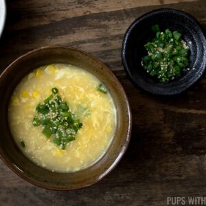 Egg drop soup in a bowl with a side of vermicelli noodles and green onions