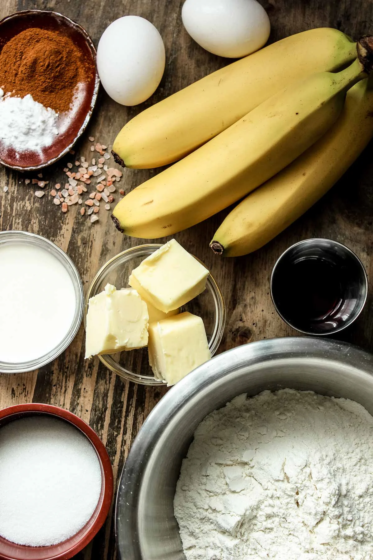 Ingredients for easy banana bread (bananas, eggs, cinnamon, butter, flour, vanilla extract, condensed milk, sugar)