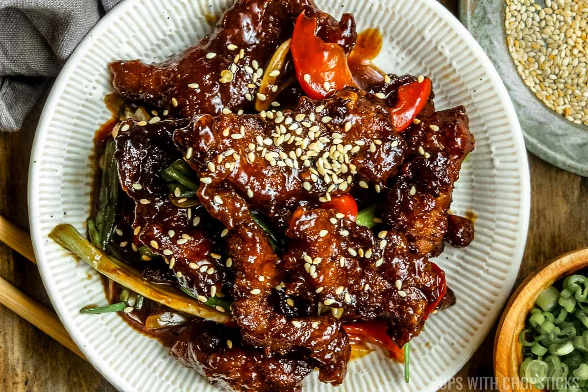Mongolian beef on a white plate with sesame seeds