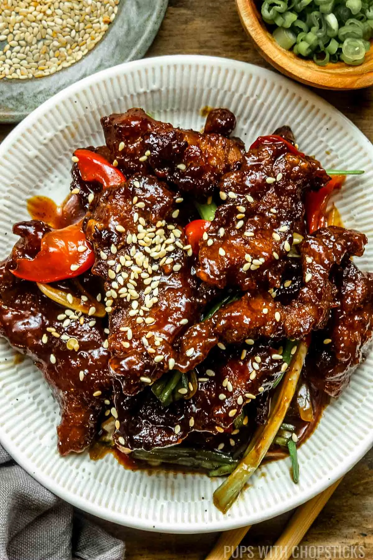 Mongolian beef on a white plate with sesame seeds