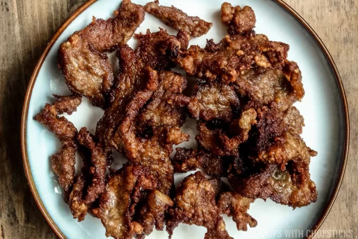 Deep fried beef on a white plate for Mongolian beef